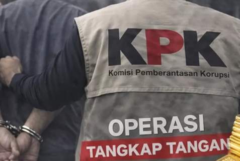 Gedung Merah Putih Komisi Pemberantasan Korupsi di Jakarta saat malam hari dengan sorotan lampu penerangan.
