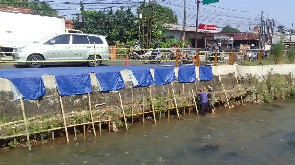 Kondisi trotoar yang amblas dan rusak parah di Jalan Raya Sawangan, Depok, di dekat kawasan Kali Cabang Tengah.